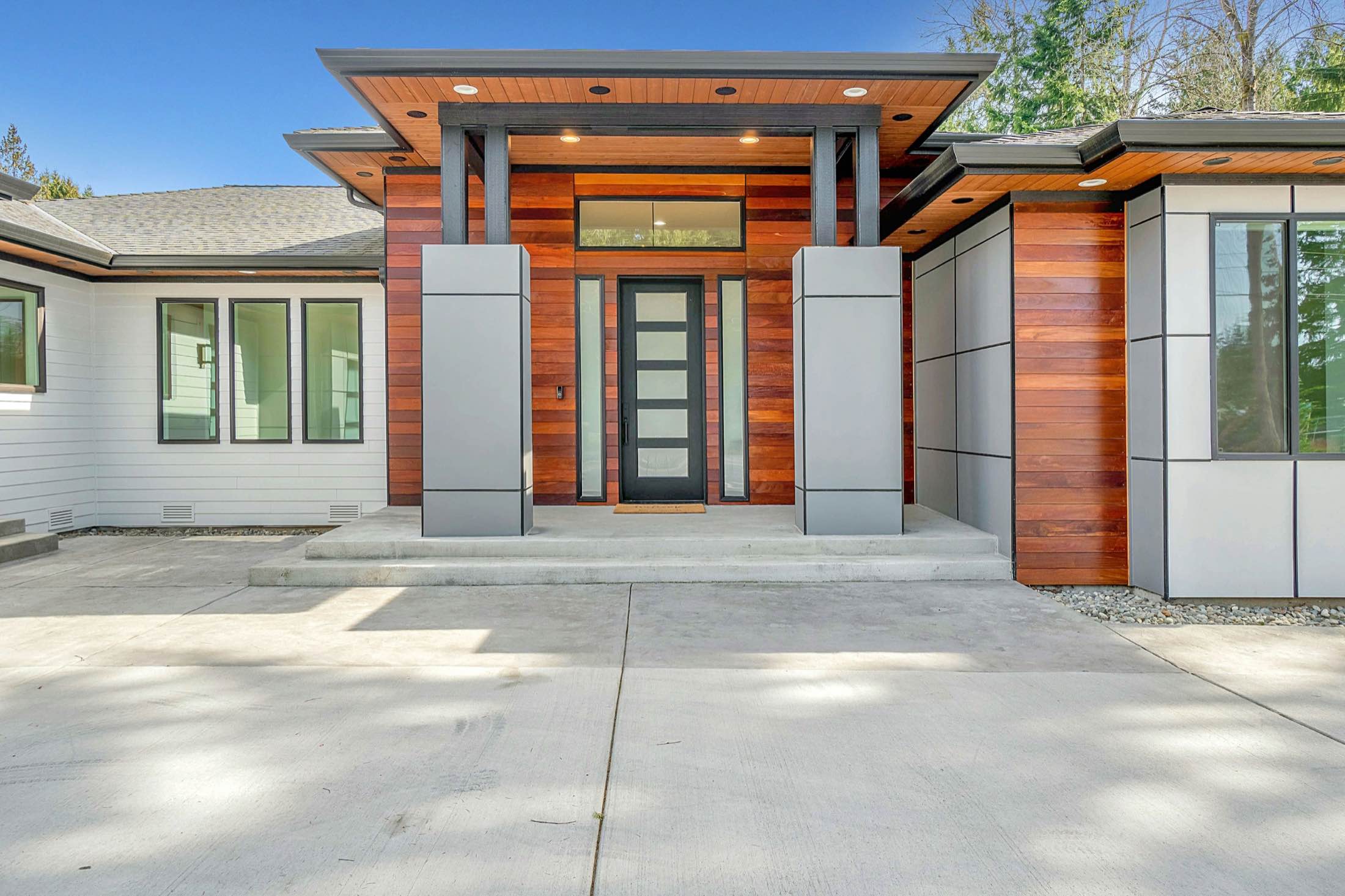 A modern home entrance clad in cedar and grey panels
