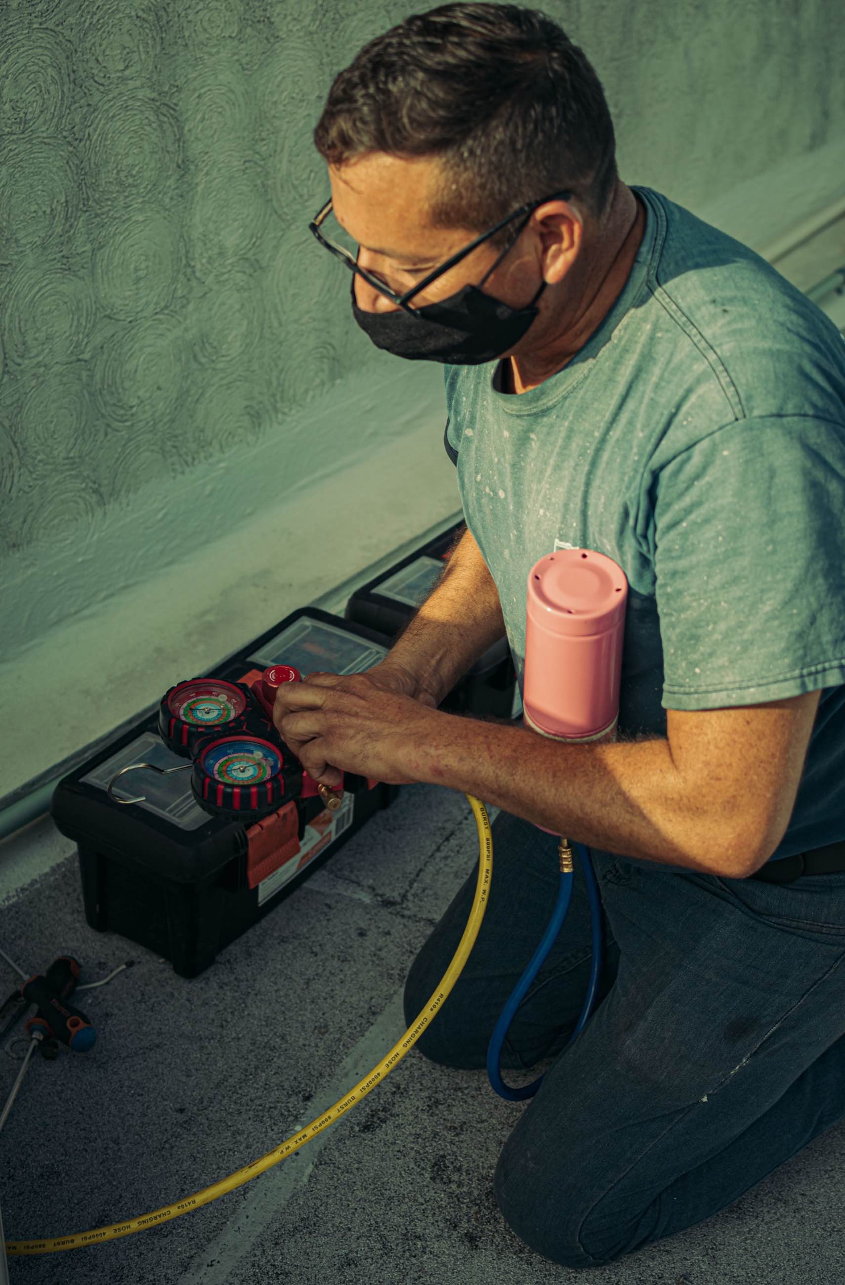 A technician reading refrigerant gauges during air-conditioning service