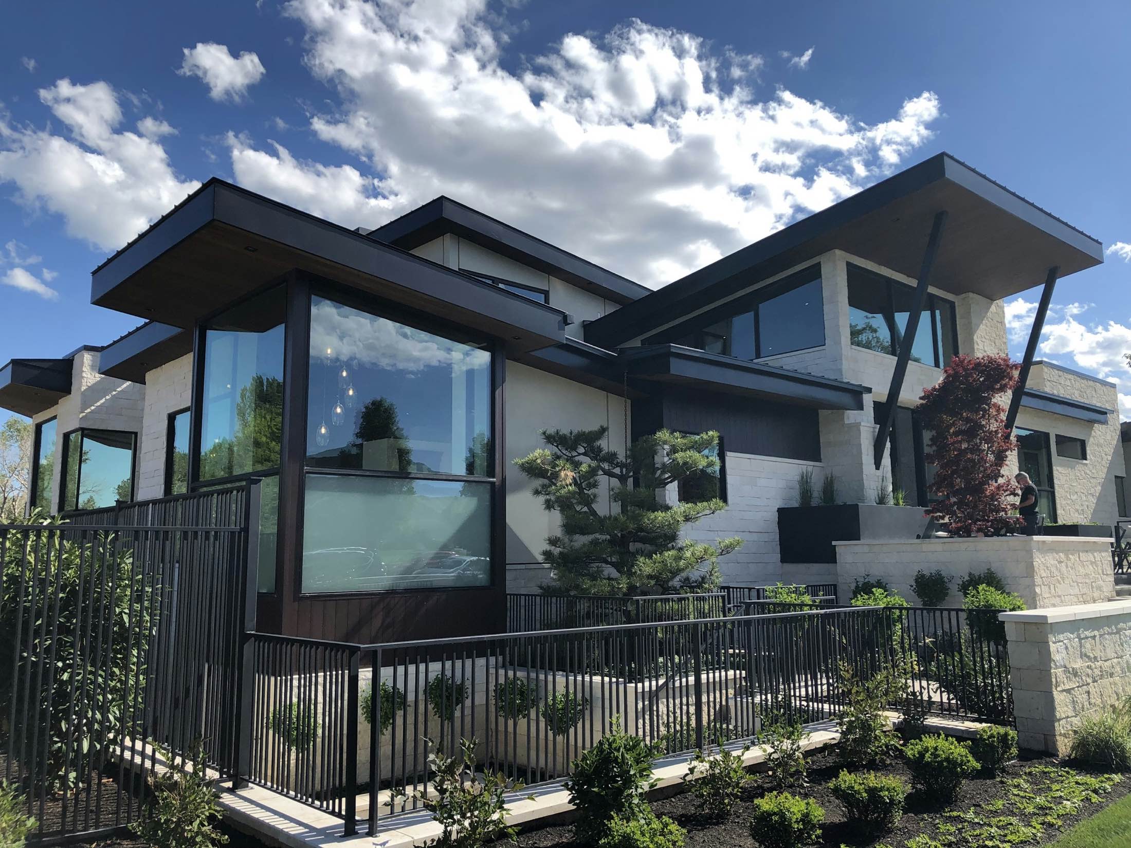 A contemporary home with angled rooflines and wide glazing under a bright sky