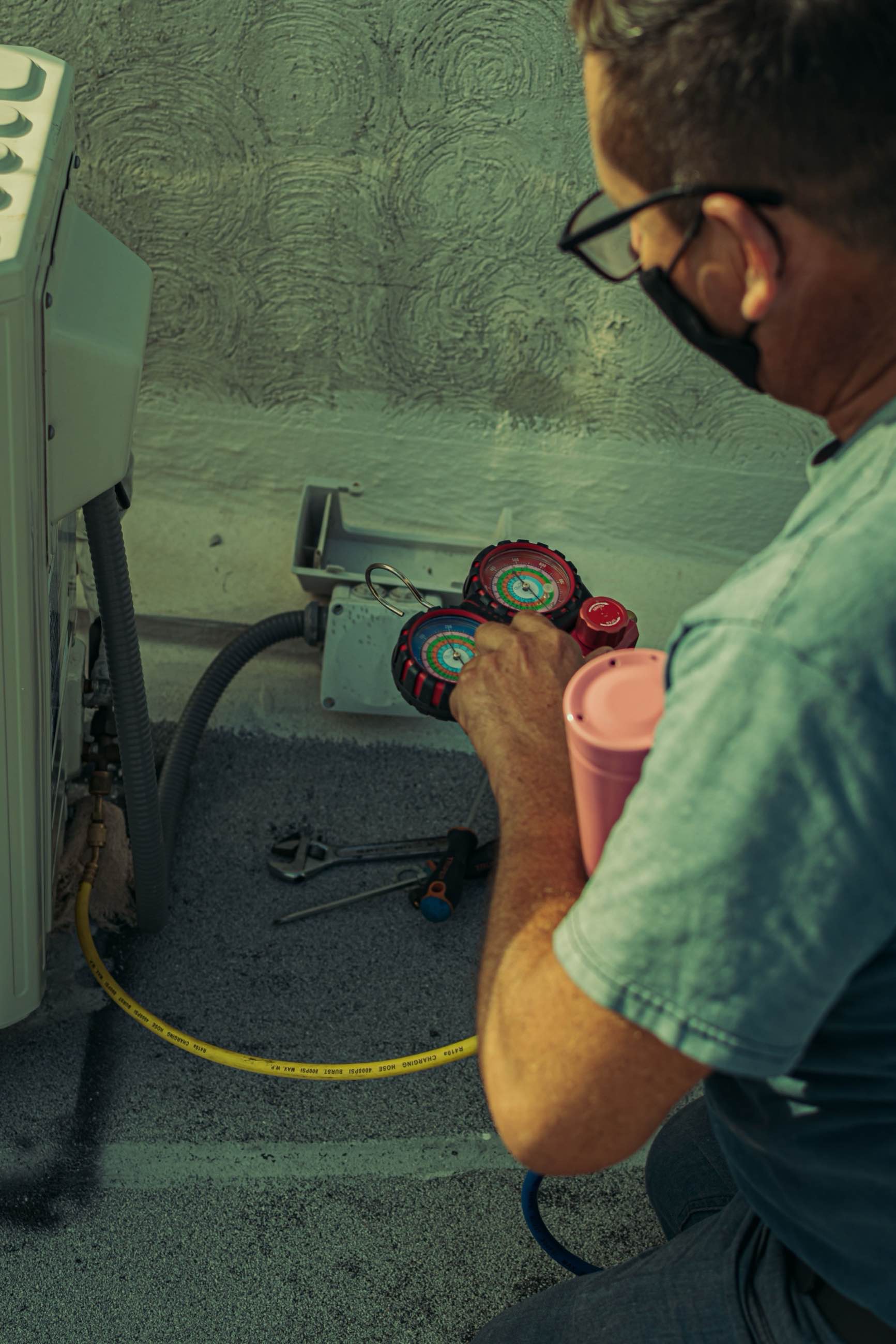 A technician checking system pressures with a manifold gauge set